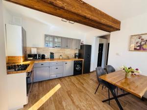 a kitchen with a wooden table and a wooden floor at Stone Apartment with sauna Sinaia in Sinaia