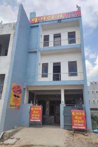 a blue building with signs in front of it at बृजराज गेस्ट हाउस & rooms in Rīngas