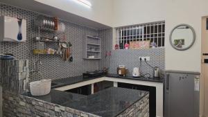 a kitchen with a black counter top and a refrigerator at June Villa Feel at Home at yelagiri hills in Yelagiri
