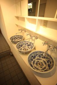 three blue and white sinks in a bathroom at Base Inn Komagome Tokyo in Tokyo
