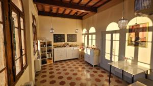 a kitchen with white cabinets and a checkered floor at Villa Palazzo Delle Erbe in Casole dʼElsa