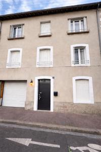 a building with a black door and two windows at Le Thuillat Limoges in Limoges