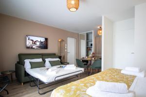 a bedroom with two beds and a living room at Hotel Le Mas de Castel - Piscine chauffee in Sarlat-la-Canéda +86 photos
