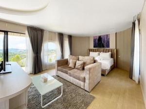 a living room with a couch and a bed at Olympus khaoyai in Ban Nong Makha