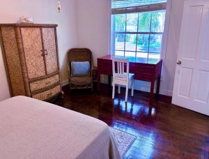 a bedroom with a desk and a dresser and a bed at The Blue Inn Family Vacation Rental in Smith Point