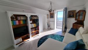 a living room with a couch and a tv and books at Marè Sunrise in Bari