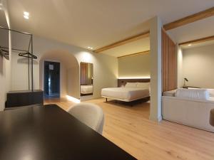 a room with two beds and a table and chairs at U-Hotel Aduana Ribadeo in Ribadeo