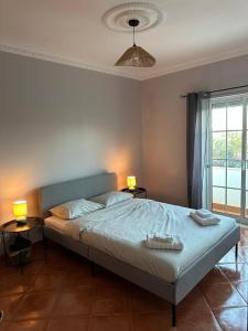 a bedroom with a bed and two lamps and a window at Casa Miramar in Tavira