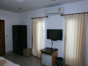 Cette chambre dispose d'une télévision, d'un lit et de rideaux. dans l'établissement Lanta Together, à Ko Lanta