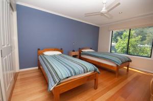 two beds in a room with blue walls and a window at Cambroe in Lakes Entrance