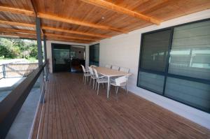 a wooden deck with a table and chairs on it at Cambroe in Lakes Entrance