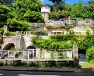 a house on the side of a hill with a lighthouse at Troglodyte Loft Natural Coolness in Saint-Étienne-de-Chigny