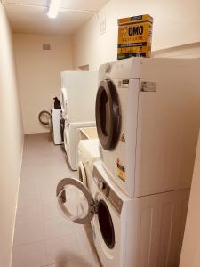 a laundry room with a stack of washers and dryers at Footsteps to Freshwater Beach in Freshwater +13 photos