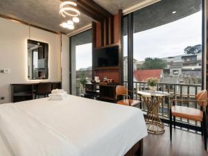 a bedroom with a large white bed and a large window at Phuc Hai Hotel Da Lat in Da Lat