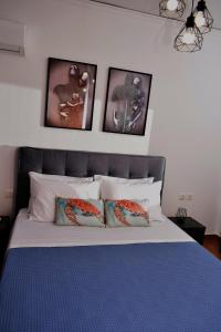a bedroom with a bed with four pictures on the wall at Art House by Helen in Soroni Rhodes in Rhodes Town