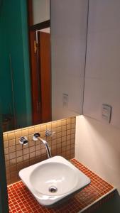 Un lavabo blanco en un baño con espejo. en Casa en las sierras, en Villa Parque Síquiman