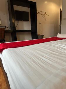 a bed with a red and white sheet on it at Sk Phuket Old Town in Phuket