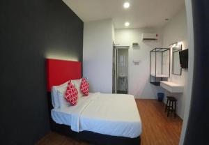 a bedroom with a bed with two red pillows on it at The Red Hotel in Bandar Saujana Putra