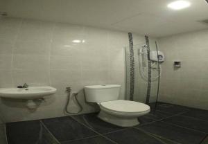 a bathroom with a shower and a toilet and a sink at The Red Hotel in Bandar Saujana Putra