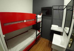a room with a red bunk bed with a mirror at The Red Hotel in Bandar Saujana Putra +3 photos