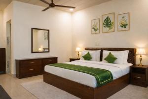 a bedroom with a large bed and a mirror at Ekantam Riverside Resort in Bijni
