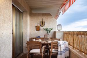 a porch with a table and chairs on a balcony at Impressive beachfront home in Calafell