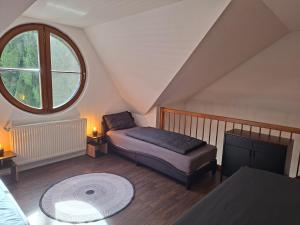 a attic room with a bed and a window at Apartmán 19 MEZONET in Jáchymov