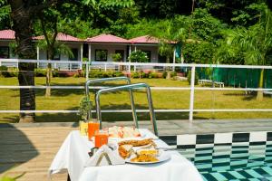 a table with a plate of food on it at Ekantam Riverside Resort in Bijni