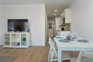 a kitchen and dining room with a white table and chairs at Panther Home Manantial in El Puerto de Santa María +36 photos