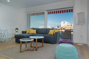 a living room with a blue couch and two tables at Panther Home Manantial in El Puerto de Santa María