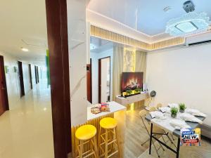 a living room with a table and yellow stools at URBAN CHIC 1Bedroom Condo Unit at MesaVirre with PlayStation 5, Pool view, and Sunset view in Bacolod +20 photos