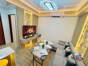 a living room with a couch and a tv at URBAN CHIC 1Bedroom Condo Unit at MesaVirre with PlayStation 5, Pool view, and Sunset view in Bacolod