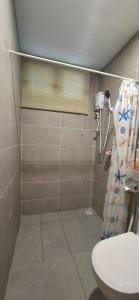 a bathroom with a toilet and a shower curtain at D'Millenia Residences Steady in Kota Samarahan +20 photos
