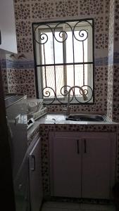 a kitchen with a sink and a mirror on the wall at MB California Guest House in Bonabéri