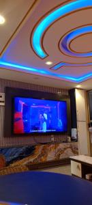 a living room with a large flat screen tv at MB California Guest House in Bonabéri