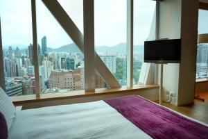 um quarto com uma grande janela com vista para a cidade em Hotel Madera Hong Kong em Hong Kong