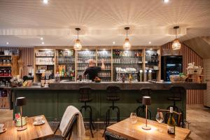 a bar in a restaurant with two tables and a bartender at Un grain d'folie in Villié-Morgon