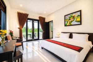 a bedroom with a bed and a desk at The Son Villa Hội An in Danang