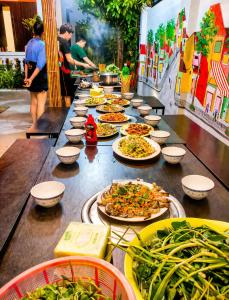 a long table with plates of food on it at The Son Villa Hội An in Danang