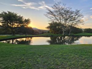 a pond on a golf course at sunset at Kruger park lodge 517 in Hazyview