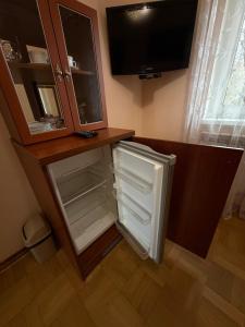 a kitchen with an open refrigerator and a tv at Luxury Apartaments 3 in Truskavets