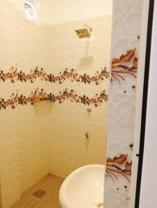 a bathroom with a shower with a toilet and a sink at Mano Holiday Guest House in Kalkudah