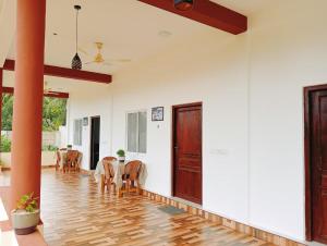 a hallway with a table and chairs in a house at Mano Holiday Guest House in Kalkudah