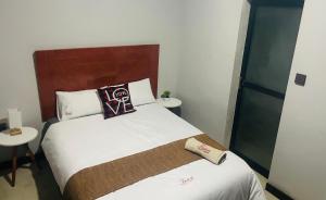 a hotel room with a bed with a pillow on it at Fusion Apartments in Lusaka