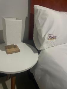 a white pillow sitting on top of a bed next to a table at Fusion Apartments in Lusaka +3 photos