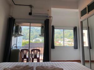 a bedroom with a bed and a view of a balcony at Silver Oaks Hotel in Patong Beach