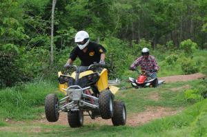 a man riding a four wheeler down a dirt road at Springfield Village Golf & Spa in Cha Am