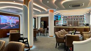 a restaurant with tables and chairs and a bar at Springfield Village Golf & Spa in Cha Am