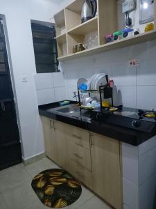 a kitchen with a sink and a black counter top at Bnb syokimau in Syokimau