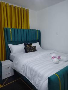 a bedroom with a bed with a blue headboard at Bnb syokimau in Syokimau